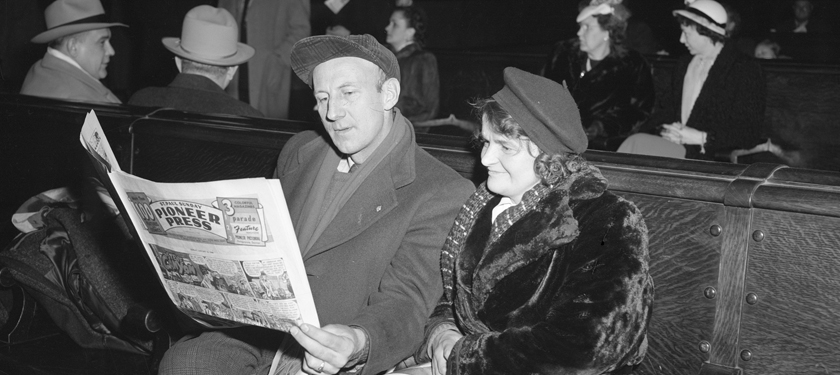 Historic photo of man and women reading newspaper in Waiting Room