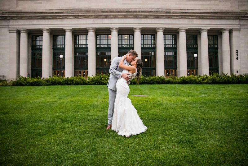 Bride and groom kissing on North Plaza lawn