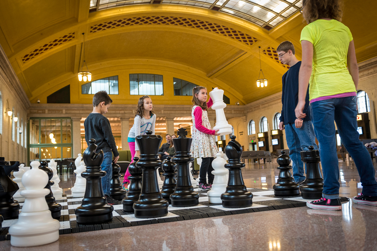 Kids playing giant chess in Union Depot's Waiting Room